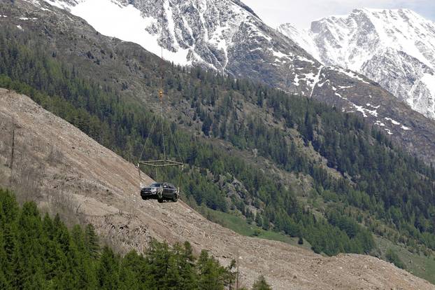 A car is carried by helicopter near Blatten