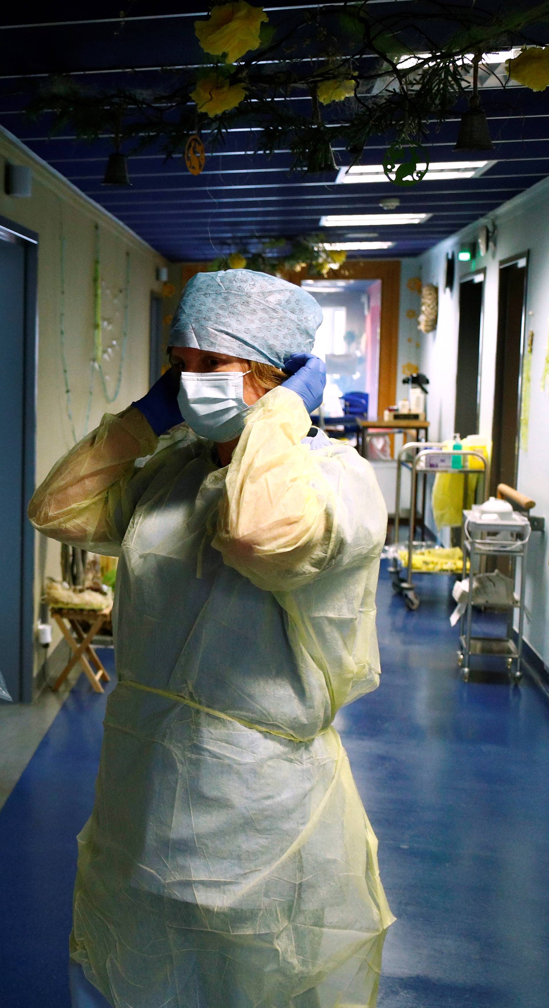 Belgian doctor adjusts her protective gear in a hospital near Arlon