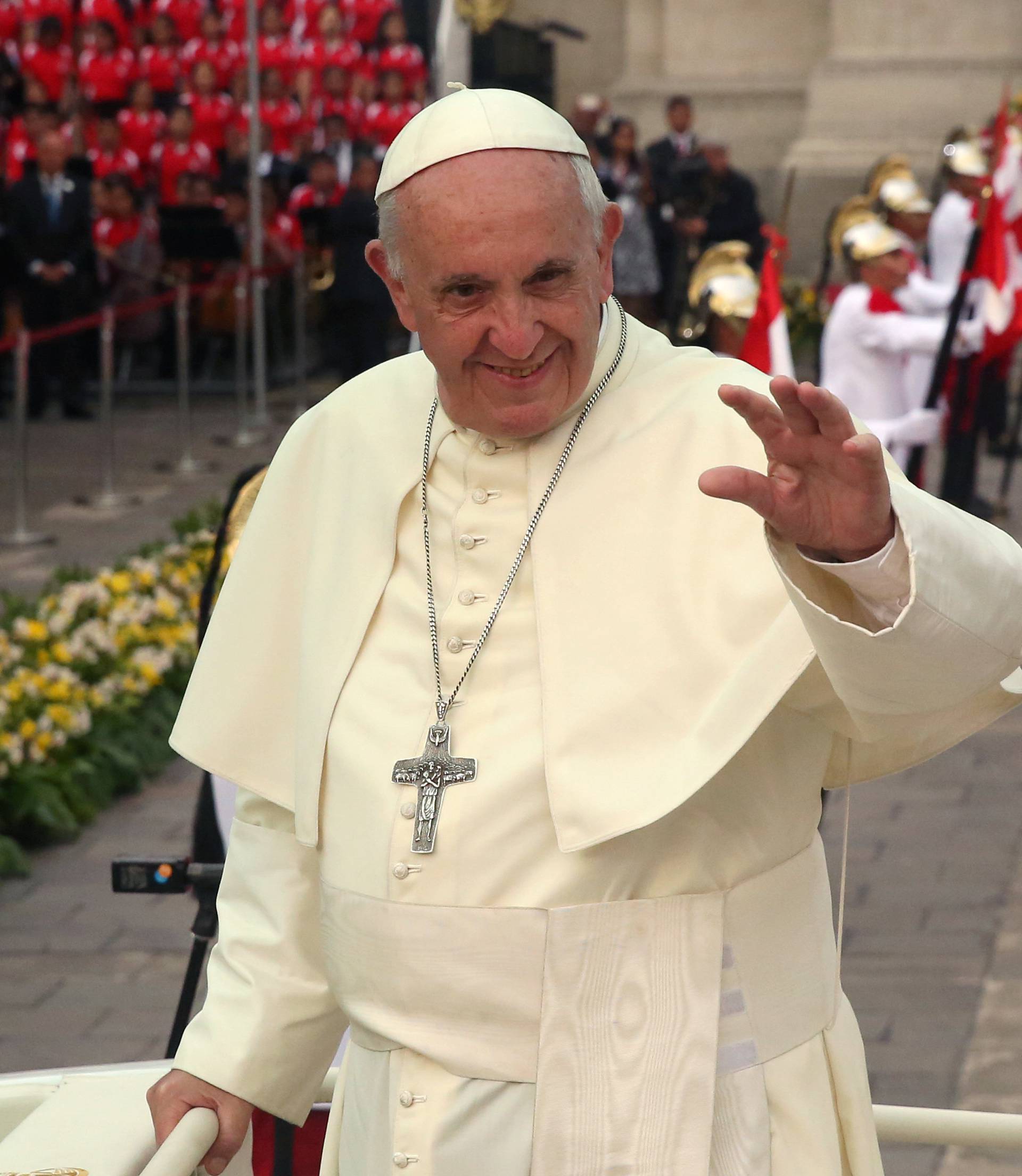 Pope Francis waves as he leaves the presidential palace in Lima