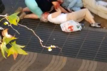 People attend to injured persons at the scene after a van crashed into pedestrians near the Las Ramblas avenue in central Barcelona