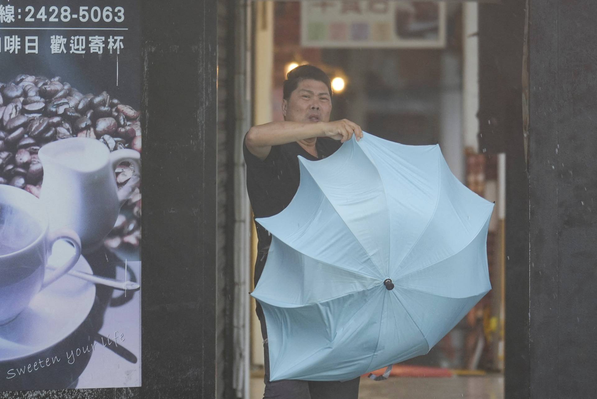 A man struggles with an umbrella, as Typhoon Kong-rey approaches in Keelung