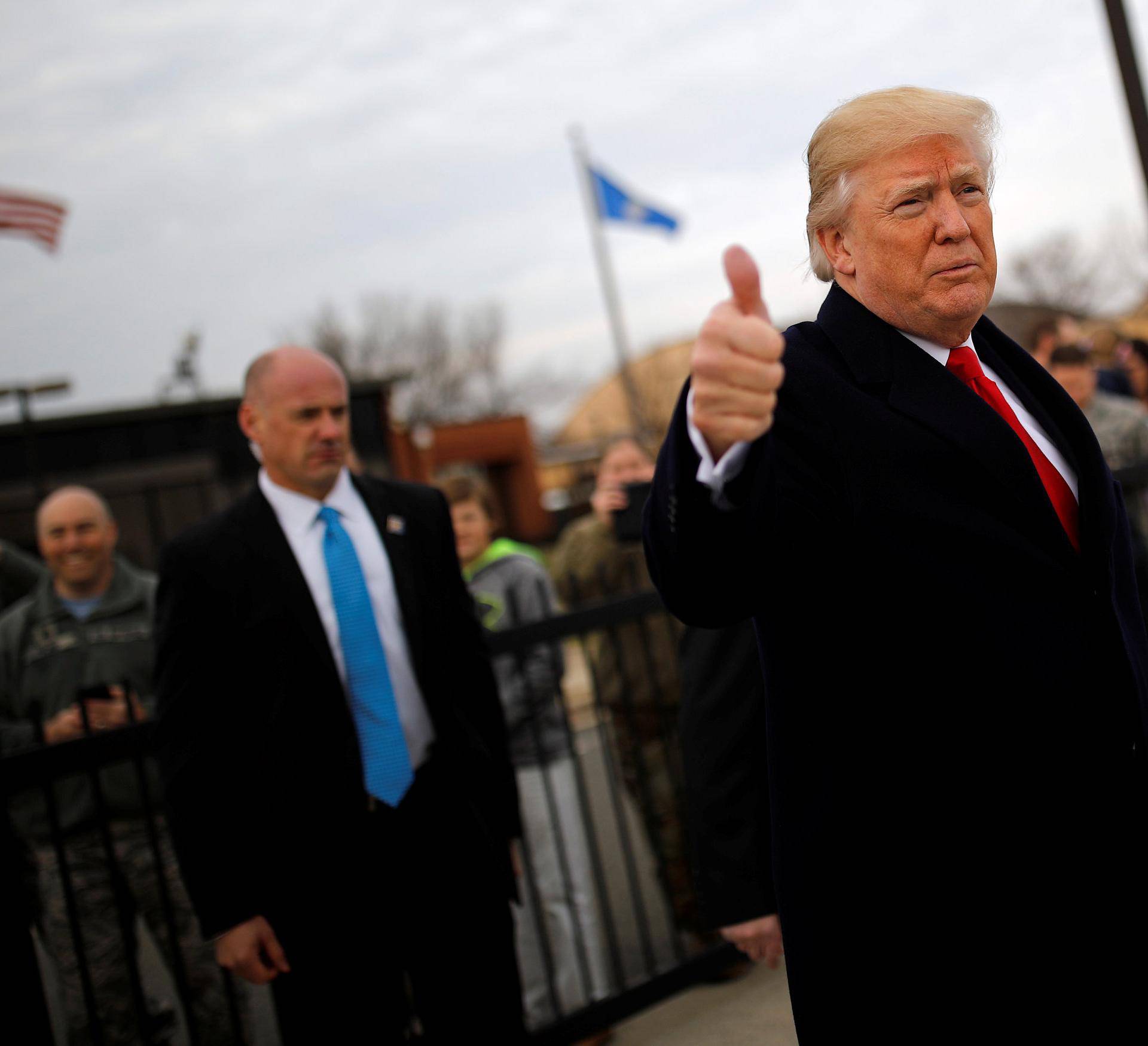 U.S. President Donald Trump gives a thumbs-up to reporters as he boards Air Force One for travel to Palm Beach from Joint Base Andrews