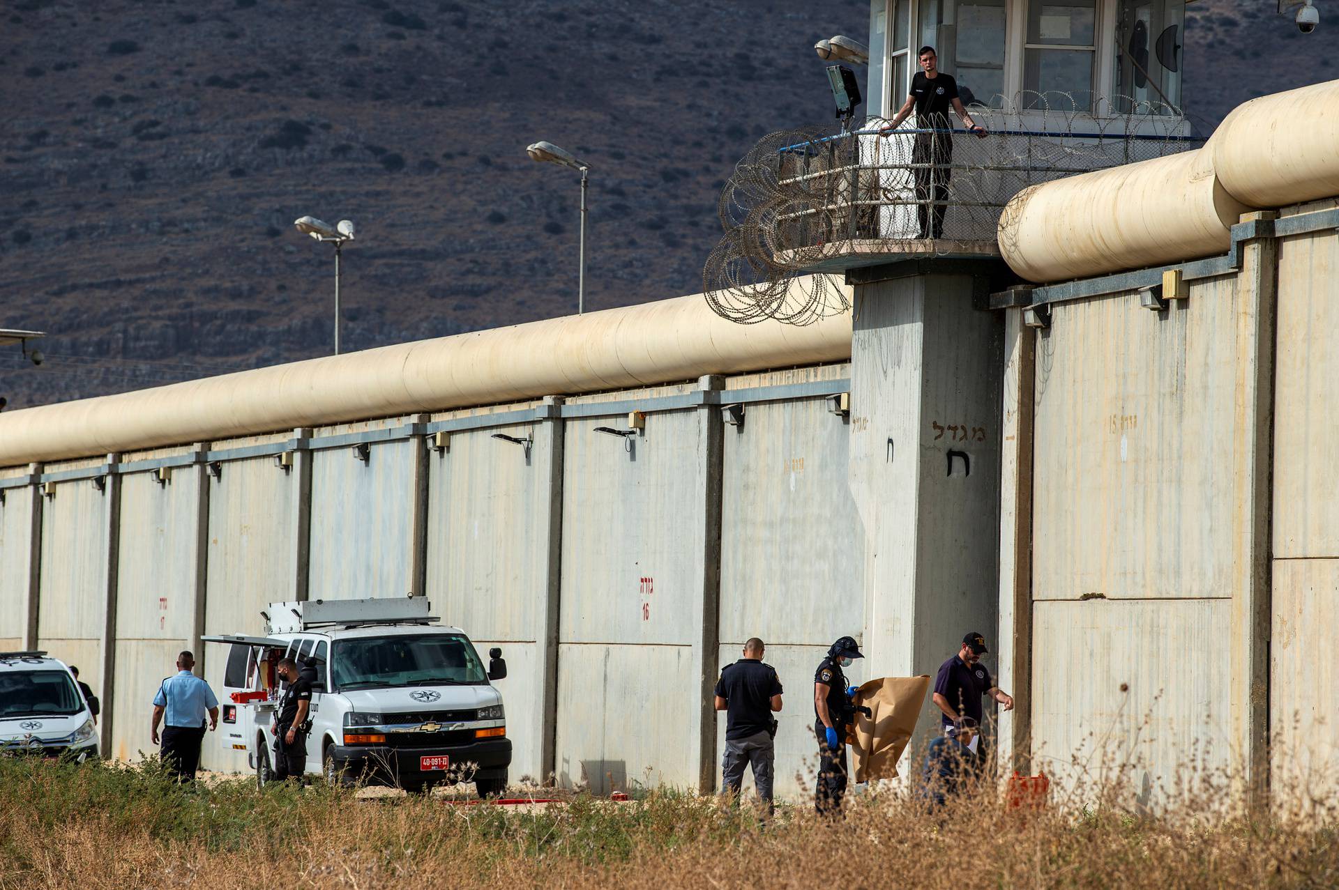Israeli security personnel stand together outside the walls of Gilboa prison after six Palestinian militants broke out of it in north Israel