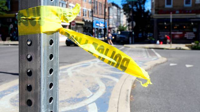 People walk past the scene after a mass shooting in Philadelphia