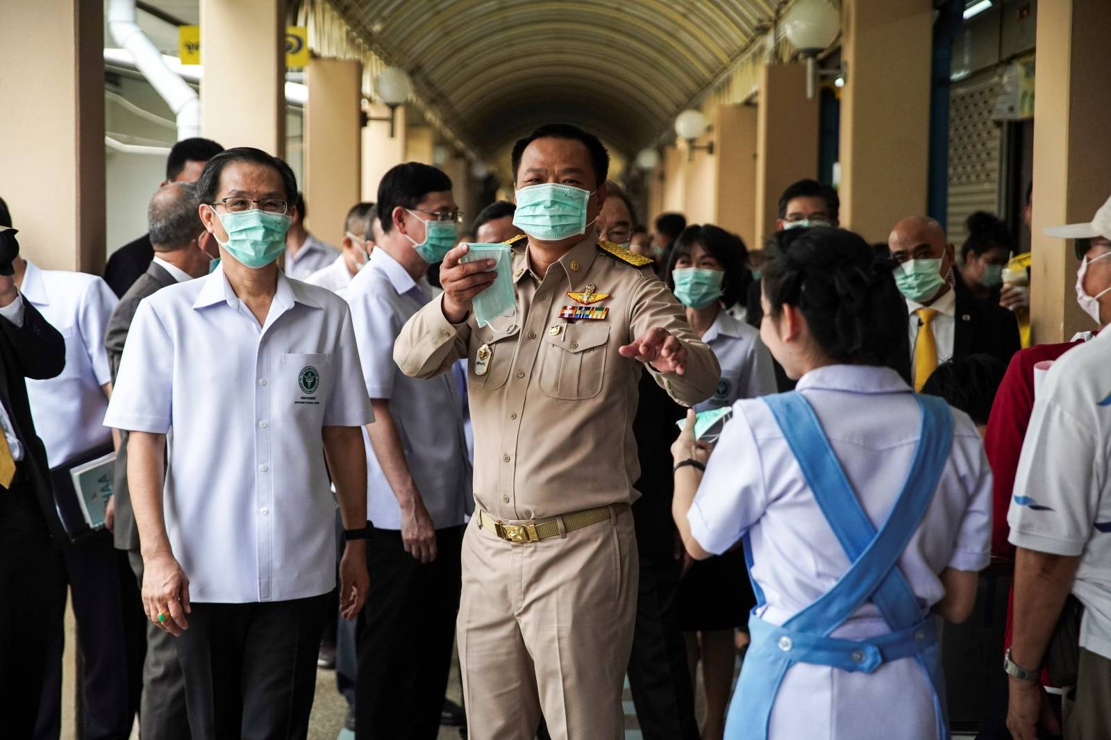 Anutin Charnvirakul, Thailand's Deputy Prime Minister and Minister of Public Health distributes protective face masks to people at a hospital before a news conference about the new coronavirus situation in Bangkok