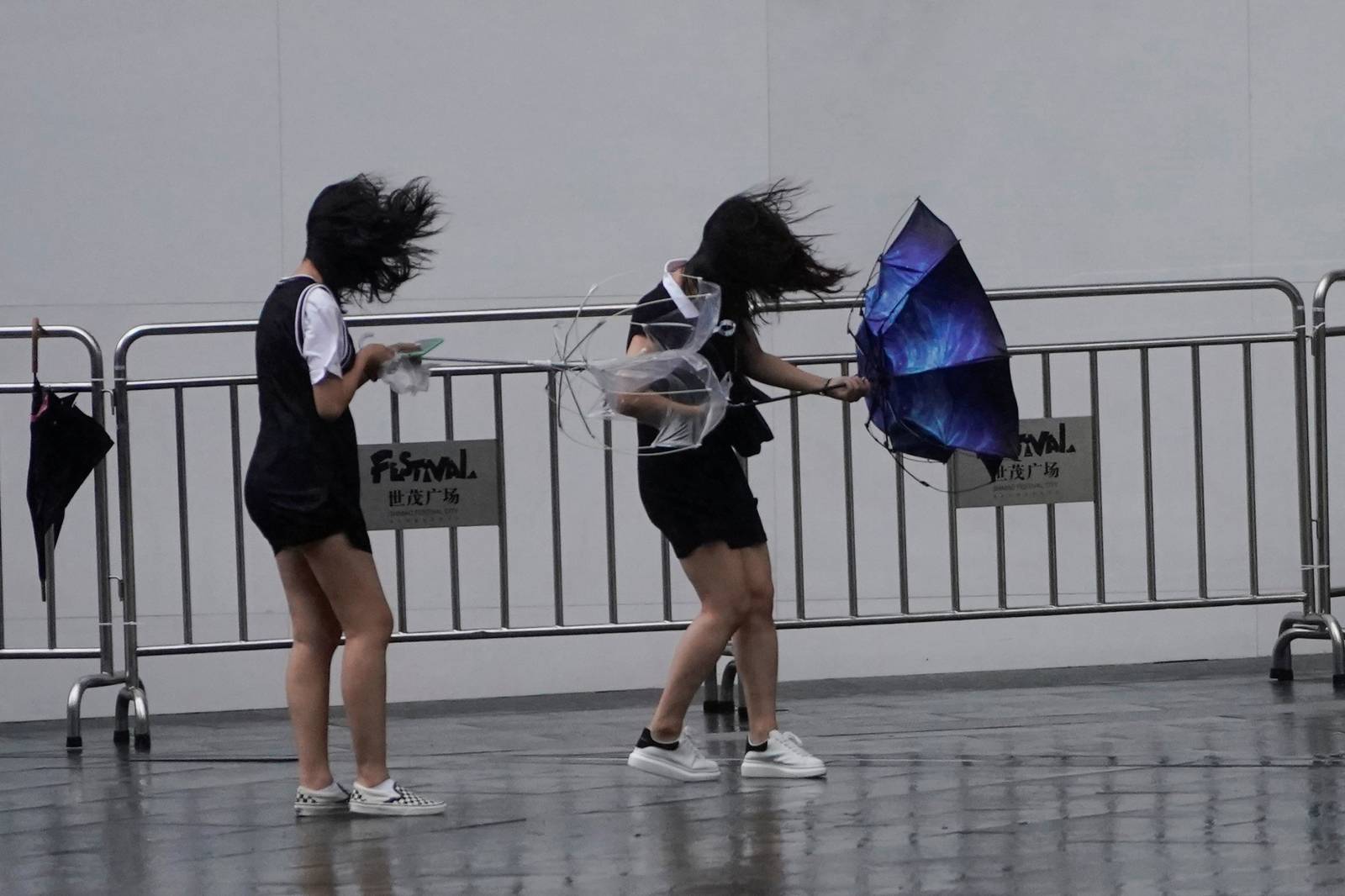 People walk in the rainstorm as typhoon Lekima approaches in Shanghai