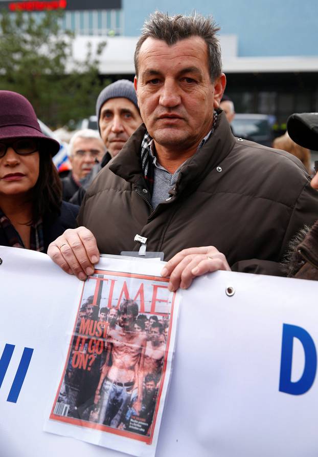 Fikret Alic, one of the survivors of concentration camps shows his photo on the cover of Time before the trial of former Bosnian Serb military commander Ratko Mladic before a court at the International Criminal Tribunal for the former Yugoslavia (ICTY) in