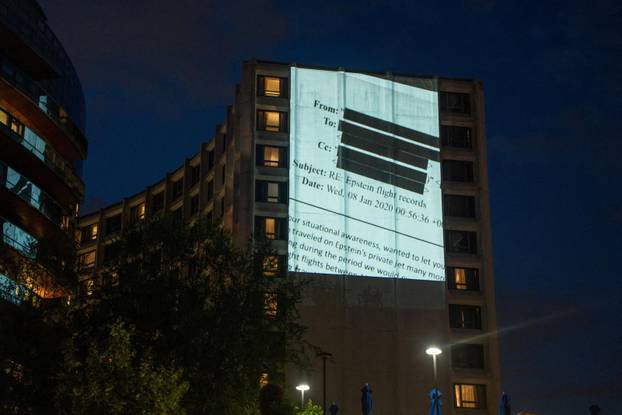 Documents and photos of Jeffrey Epstein and U.S. President Trump projected onto Hilton ahead of WHCA Gala, in Washington, D.C.
