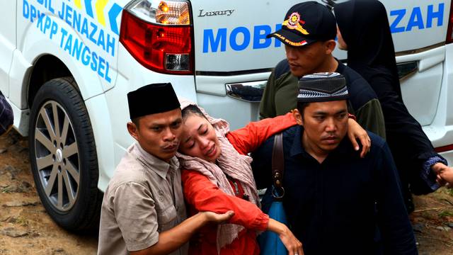 Family of a victim of deadly tour bus accident in Subang, West Java react, after ambulances brought the bodies of the victims home to South Tangerang, Banten