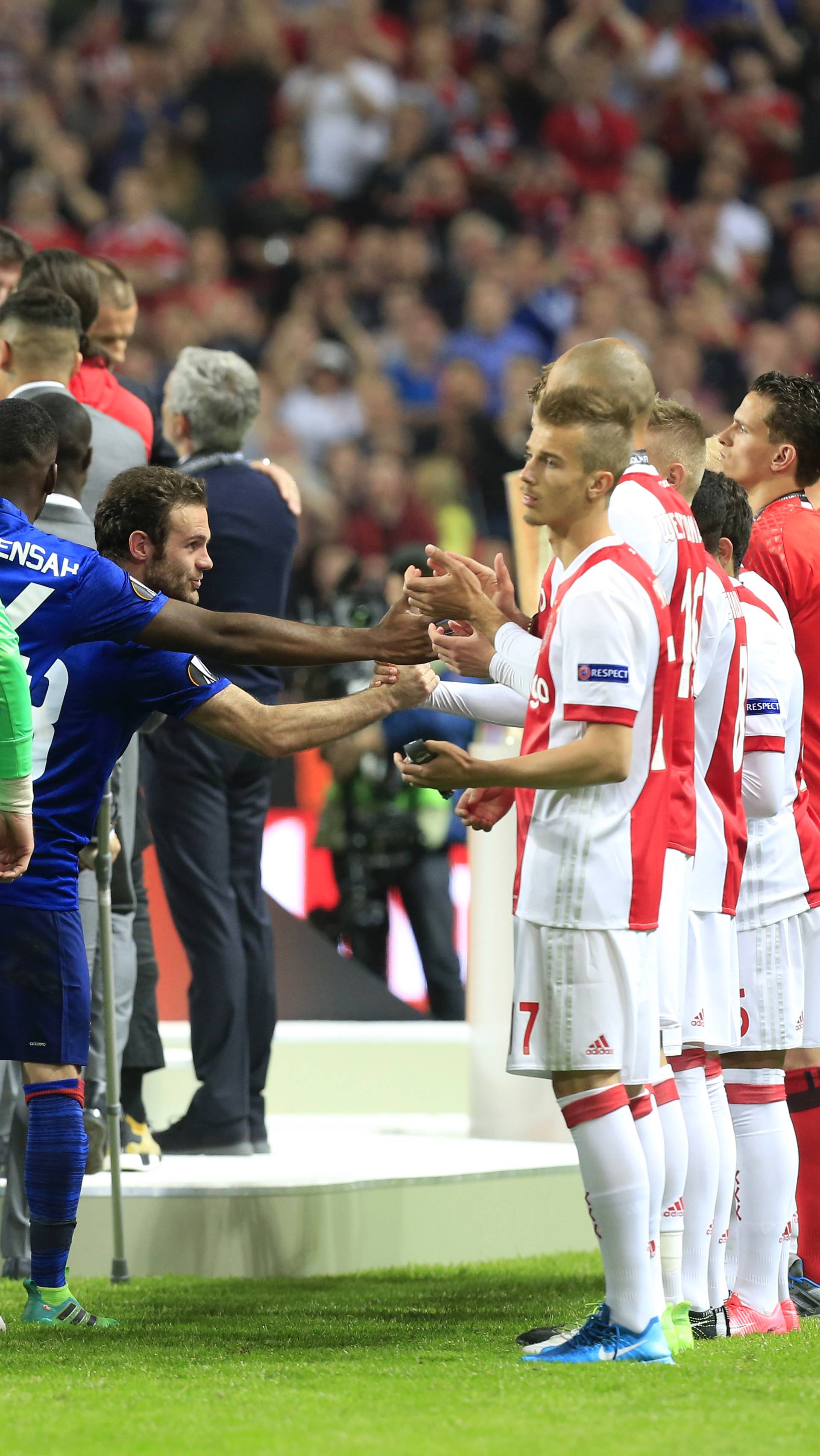 Manchester United players shake hands with Ajax players after the match
