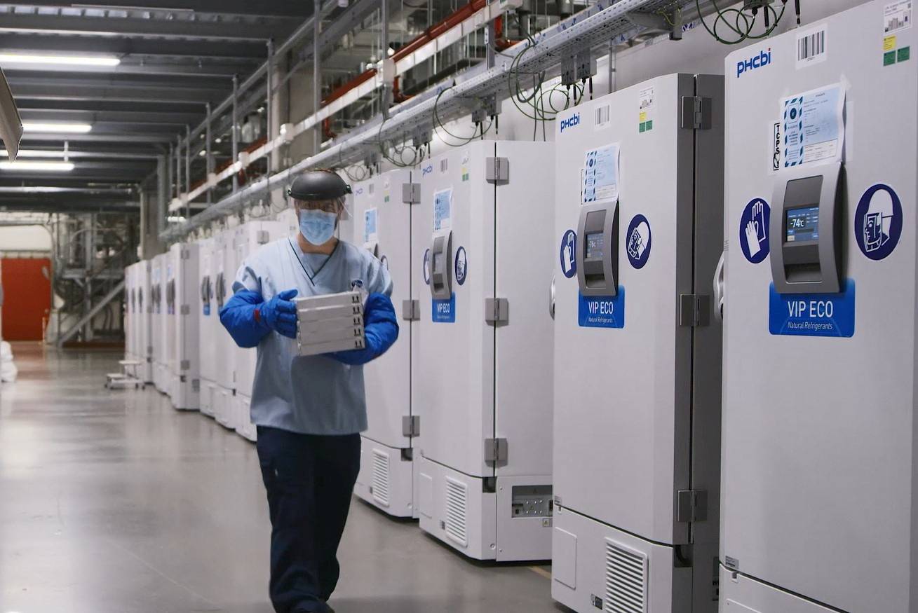 FILE PHOTO: A worker passes a line of freezers holding coronavirus disease (COVID-19) vaccine candidate BNT162b2 at a Pfizer facility in Puurs