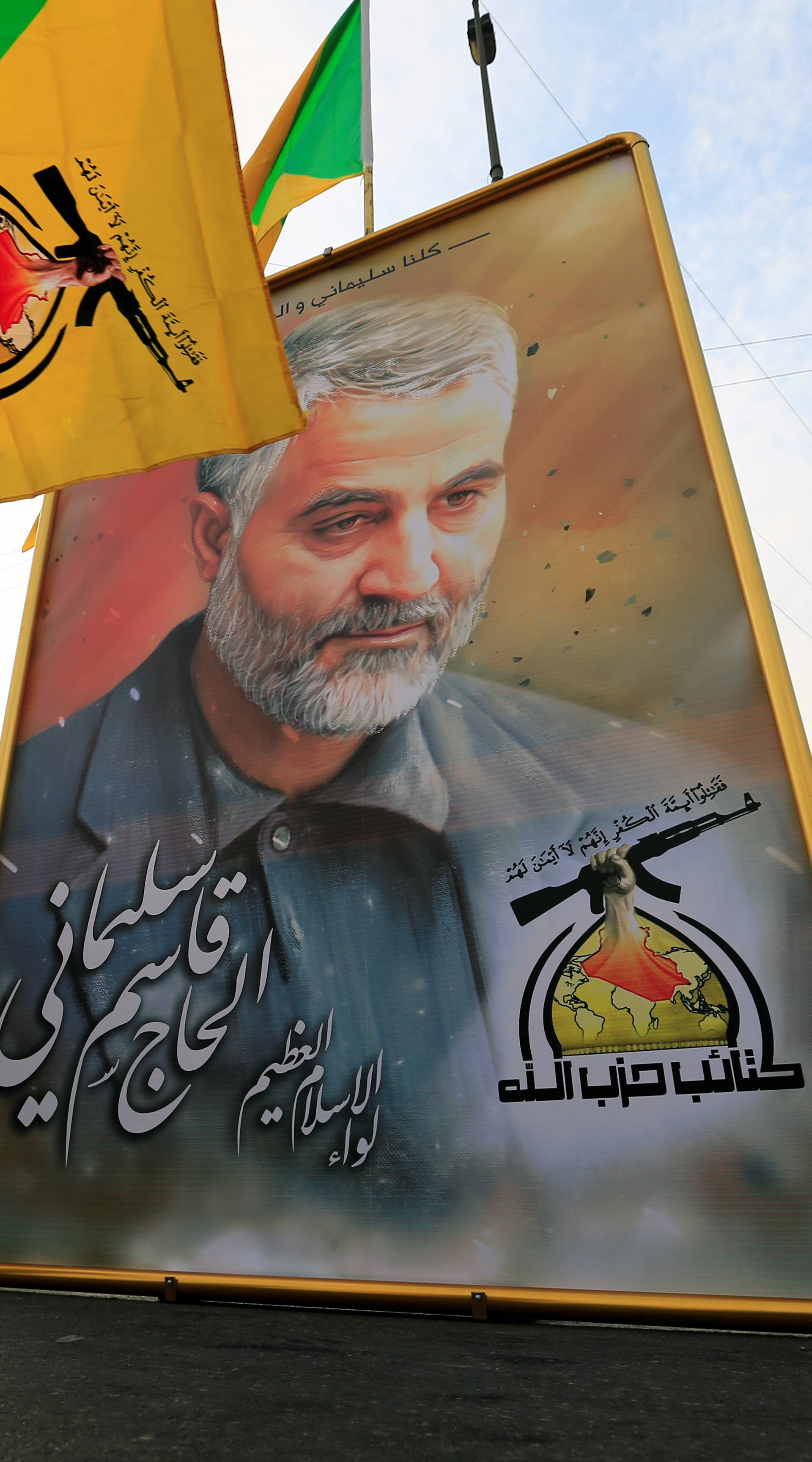 Kataib Hezbollah Iraqi militia hold the picture of the Iranian Major-General Qassem Soleimani, as they gather ahead of the funeral of the Iraqi militia commander Abu Mahdi al-Muhandis, in Baghdad