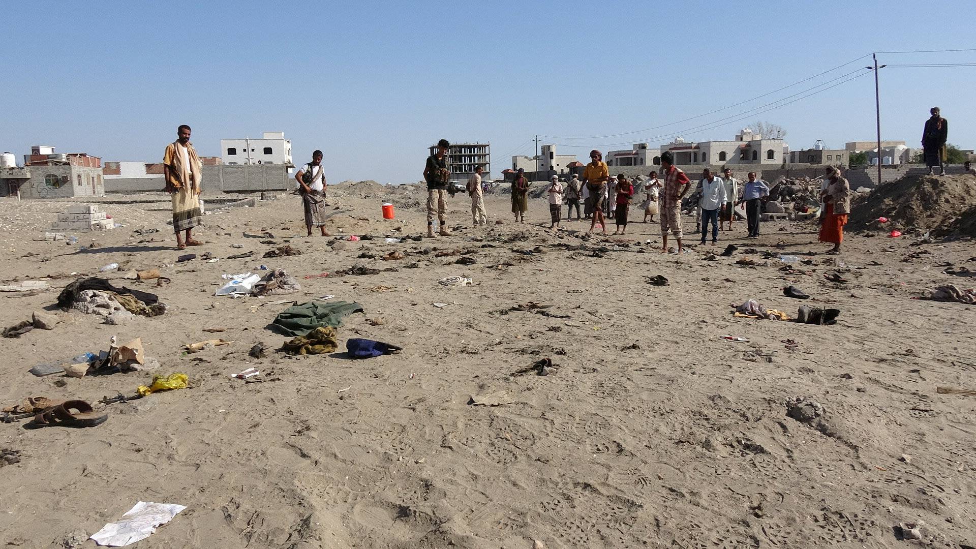 People gather at the site of a suicide bombing in the southern port city of Aden, Yemen