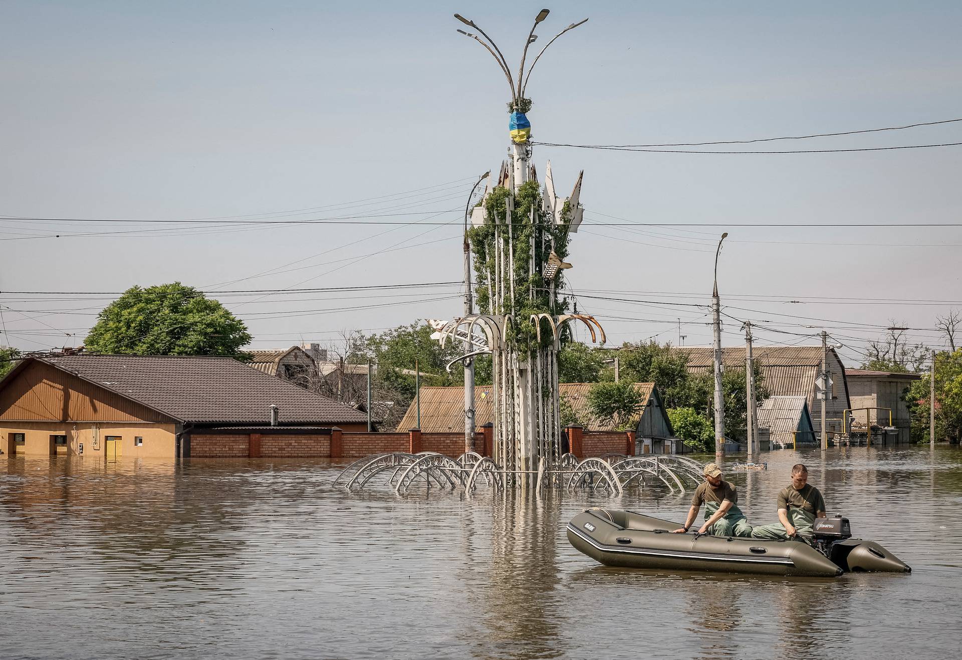 Volunteers sail on a boat during an evacuation of local residents from a flooded area after the Nova Kakhovka dam breached in Kherson