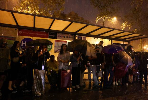Tourists and local residents shelter from heavy rain in Barcelona