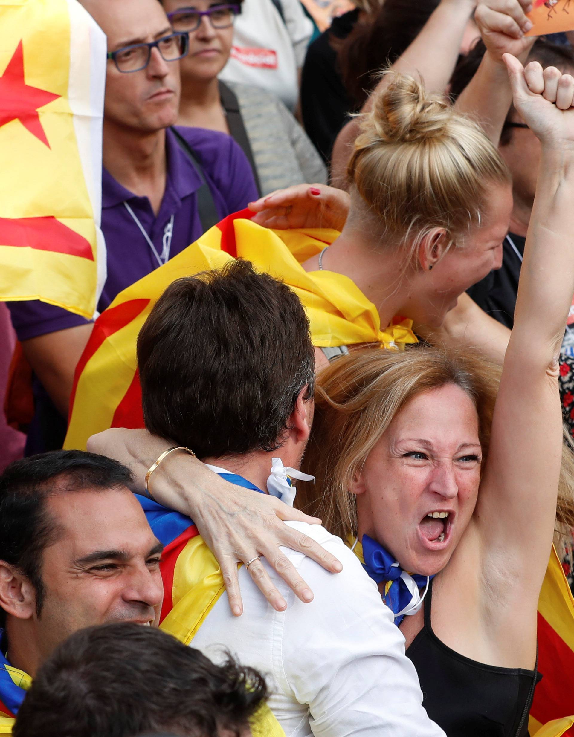 People react as they watch on giant screens a plenary session outside the Catalan regional parliament in Barcelona