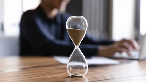 Close,Up,View,Of,Hourglass,Stand,On,Wooden,Home,Office