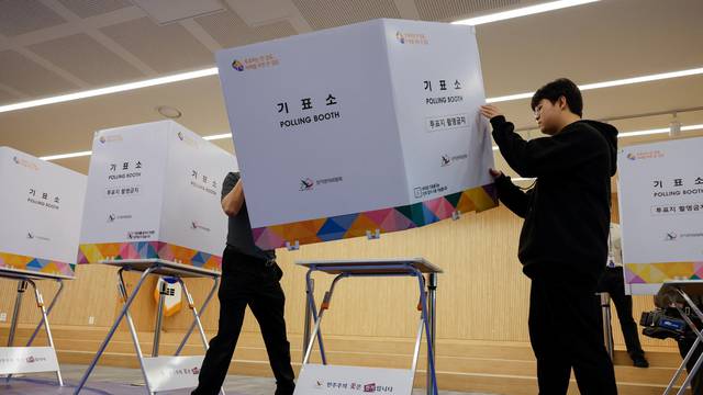 Government officials sets up a polling booth for the upcoming 22nd parliamentary election at a lifelong learning center in Seoul