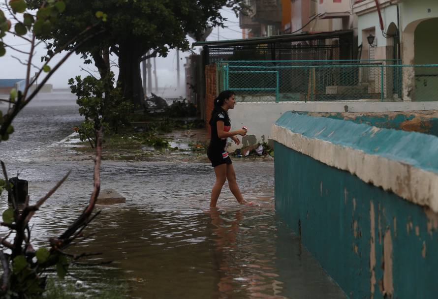 A woman wades through a flooded street as Hurricane Irma turns toward the Florida Keys on Saturday, in Havana