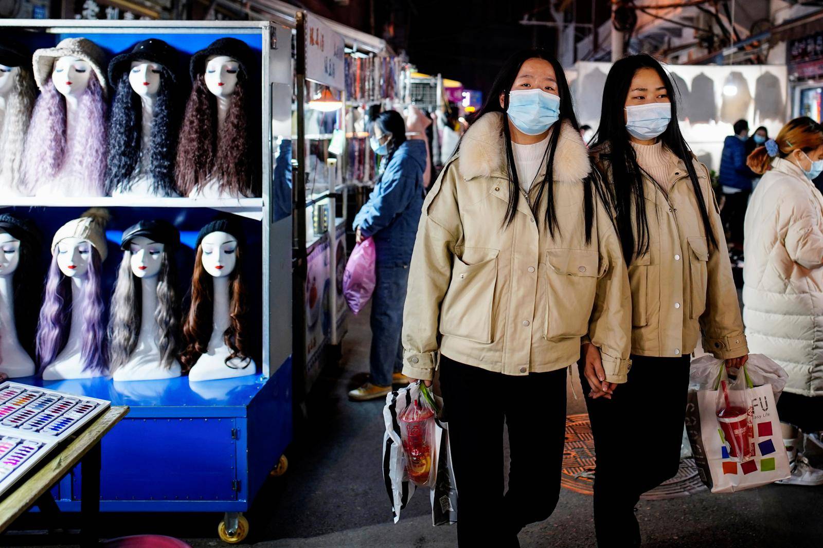 People wearing face masks visit a street market almost a year after the global outbreak of the coronavirus disease (COVID-19) in Wuhan
