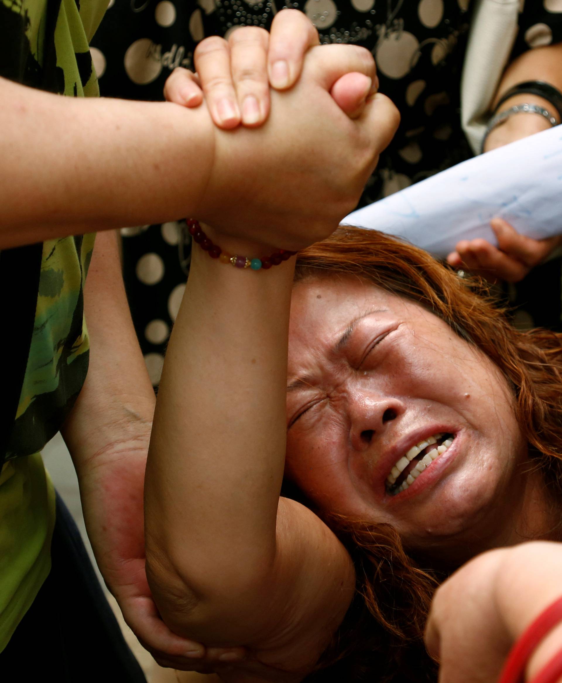 A family member of a passenger aboard Malaysia Airlines flight MH370 which went missing in 2014 reacts during a protest outside the Chinese foreign ministry in Beijing