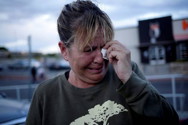 A woman reacts after a mass shooting at a Walmart in El Paso