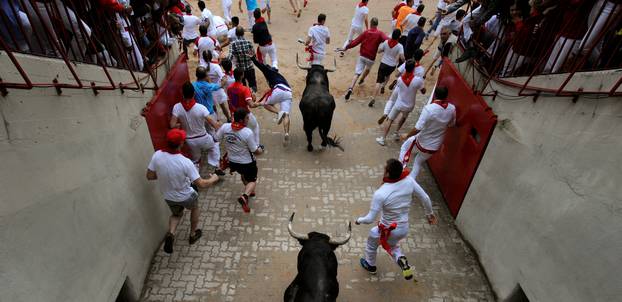 Runners sprint ahead of Fuente Ymbro fighting bulls during the fourth running of the bulls at the San Fermin festival in Pamplona