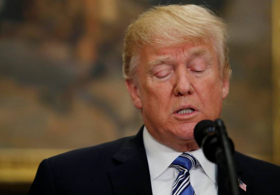 U.S. President Donald Trump signs a presidential proclamation placing tariffs on steel and aluminum imports while surrounded by workers from the steel and aluminum industries at the White House in Washington