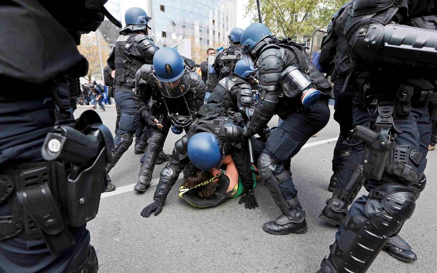 French riot police officers detain a protestor during a demonstration against the French labour law proposal in Lyon
