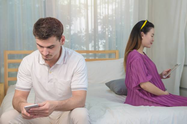 husband using Smartphone in bedroom ignoring Pregnant wife, life