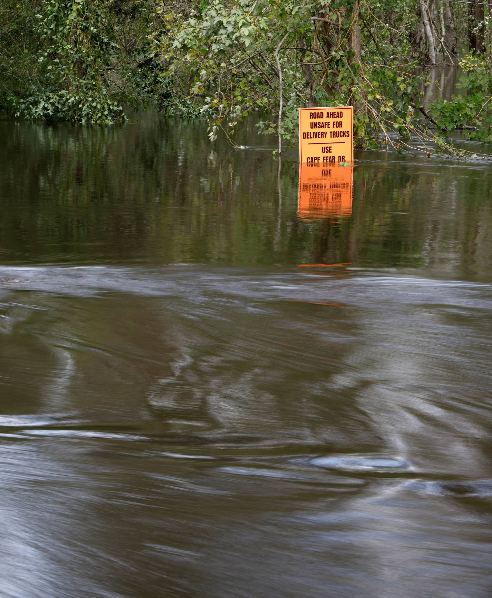 Flood waters flow around submerged street signs as the Northeast Cape Fear River breaks its banks after Hurricane Florence in Burgaw, North Carolina