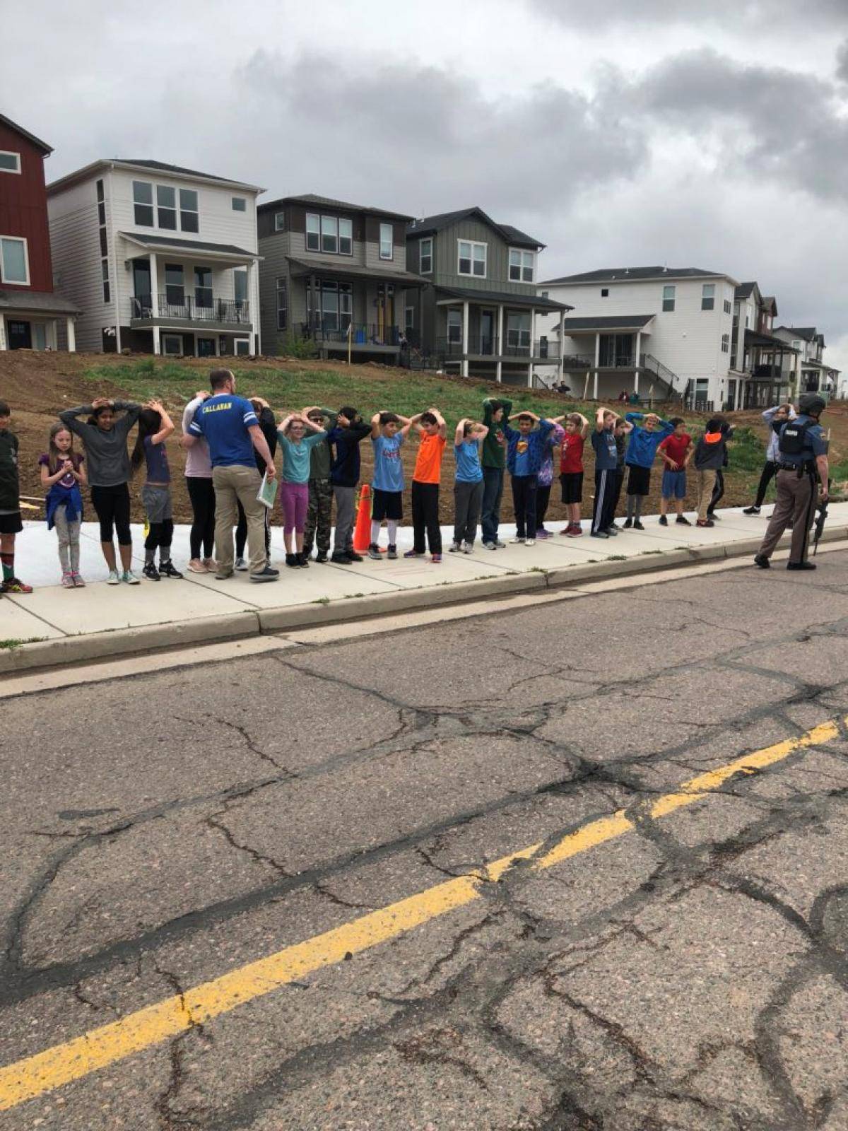 Schoolchildren stand in a line outside near the STEM School during a shooting incident in Highlands Ranch, Colorado, U.S. in this May 7, 2019 image obtained via social media