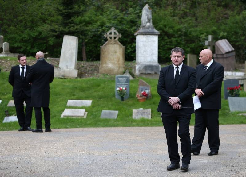 Private security guards stand outside Highgate Cemetery in London