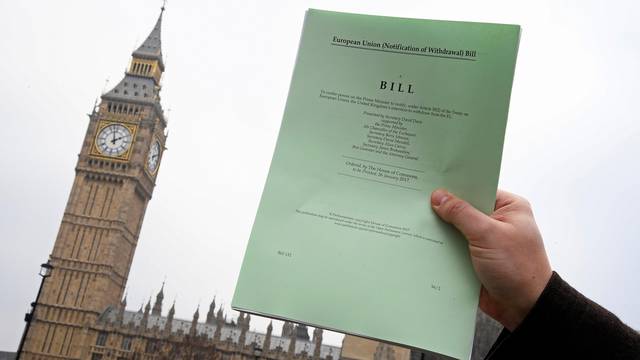 FILE PHOTO: A journalist poses with a copy of the Brexit Article 50  bill, introduced by the government to seek parliamentary approval to start the process of leaving the European Union, in London