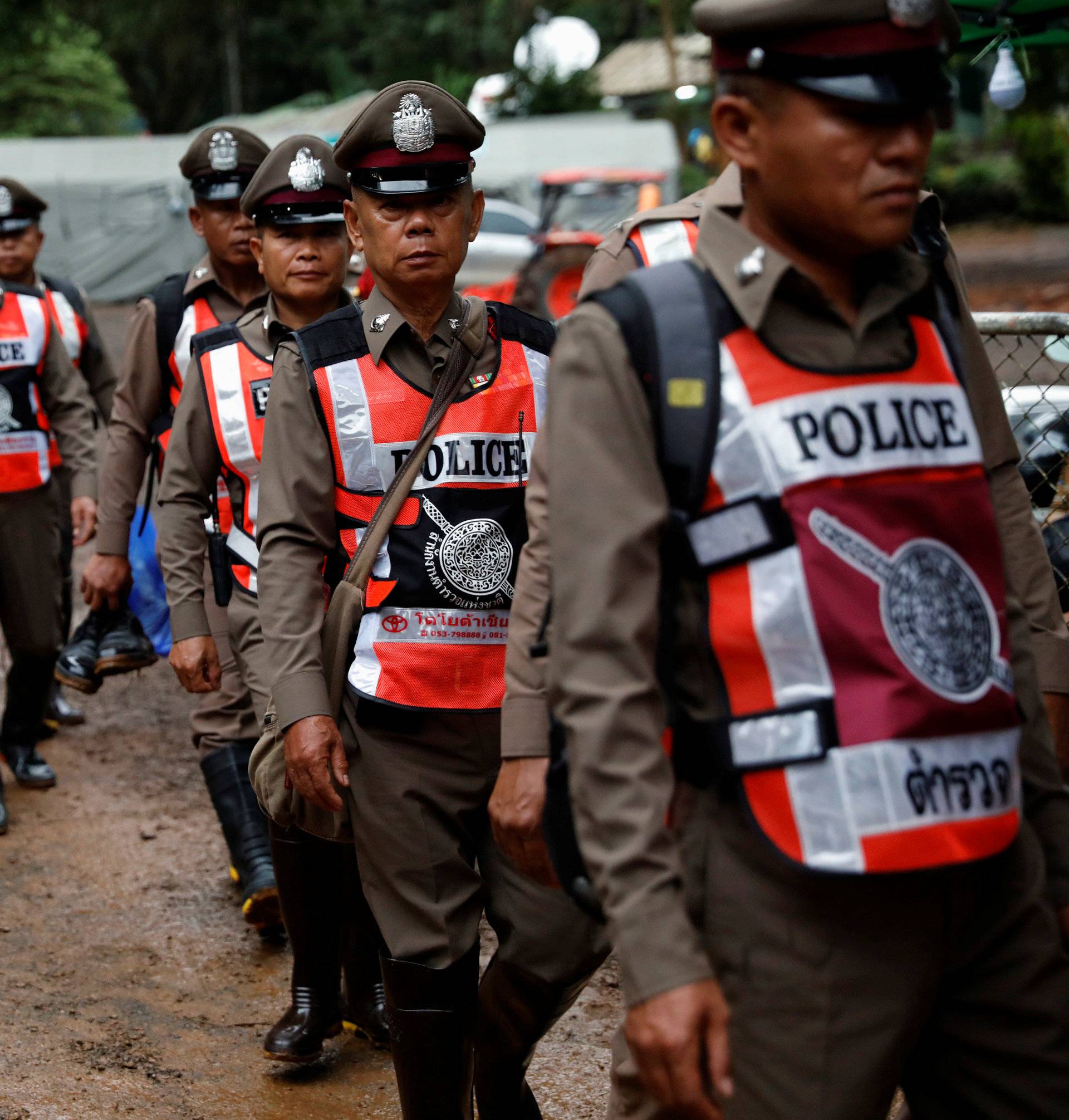 Police officers walk near Tham Luang cave complex, as members of an under-16 soccer team and their coach have been found alive according to a local media report, in Chiang Rai