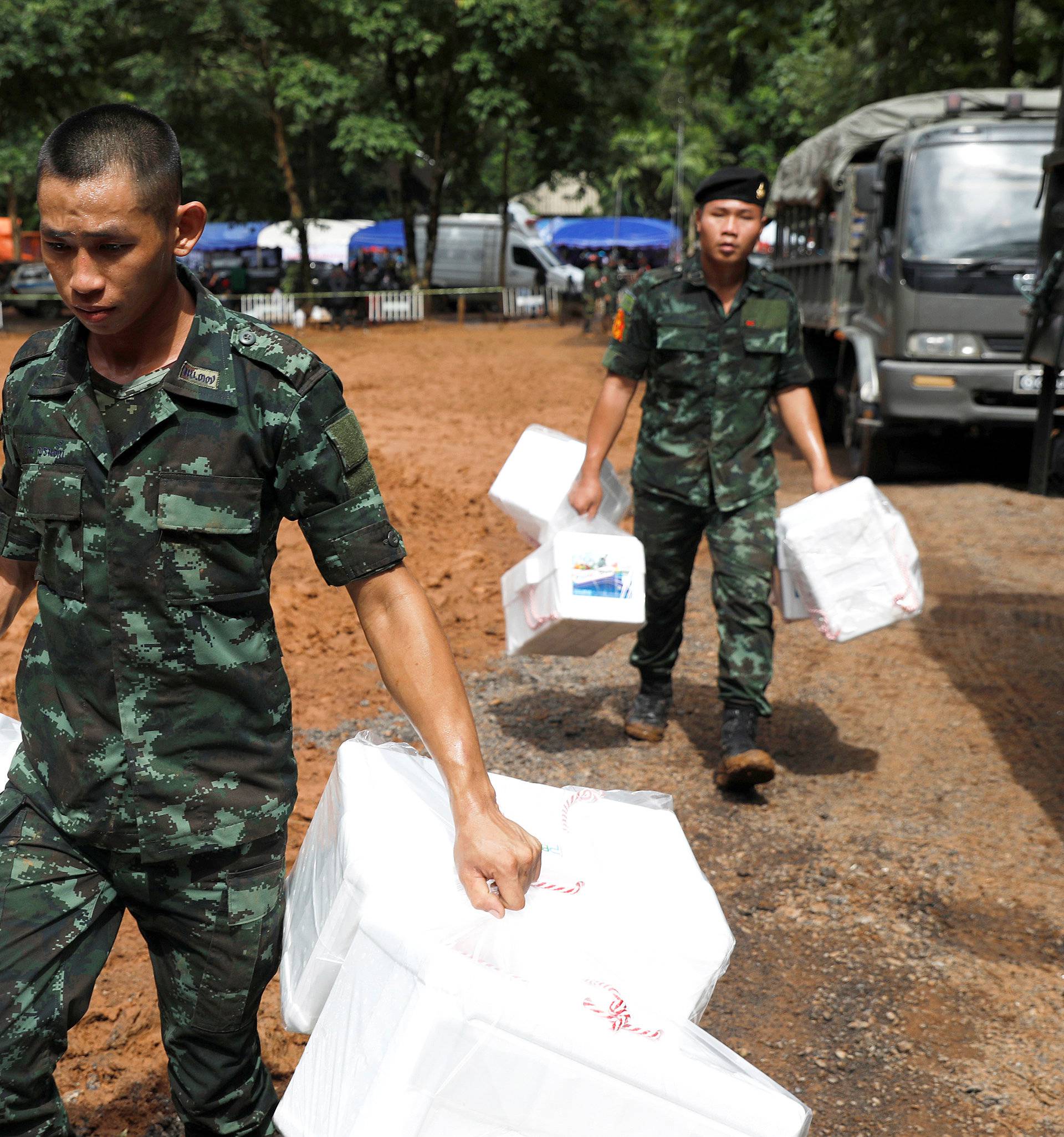 Soldiers unload aids near the Tham Luang cave complex, as a search for members of an under-16 soccer team and their coach continues, in the northern province of Chiang Rai