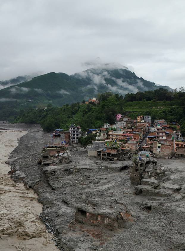 A drone view shows mud covering properties following a flash flood in Trishuli