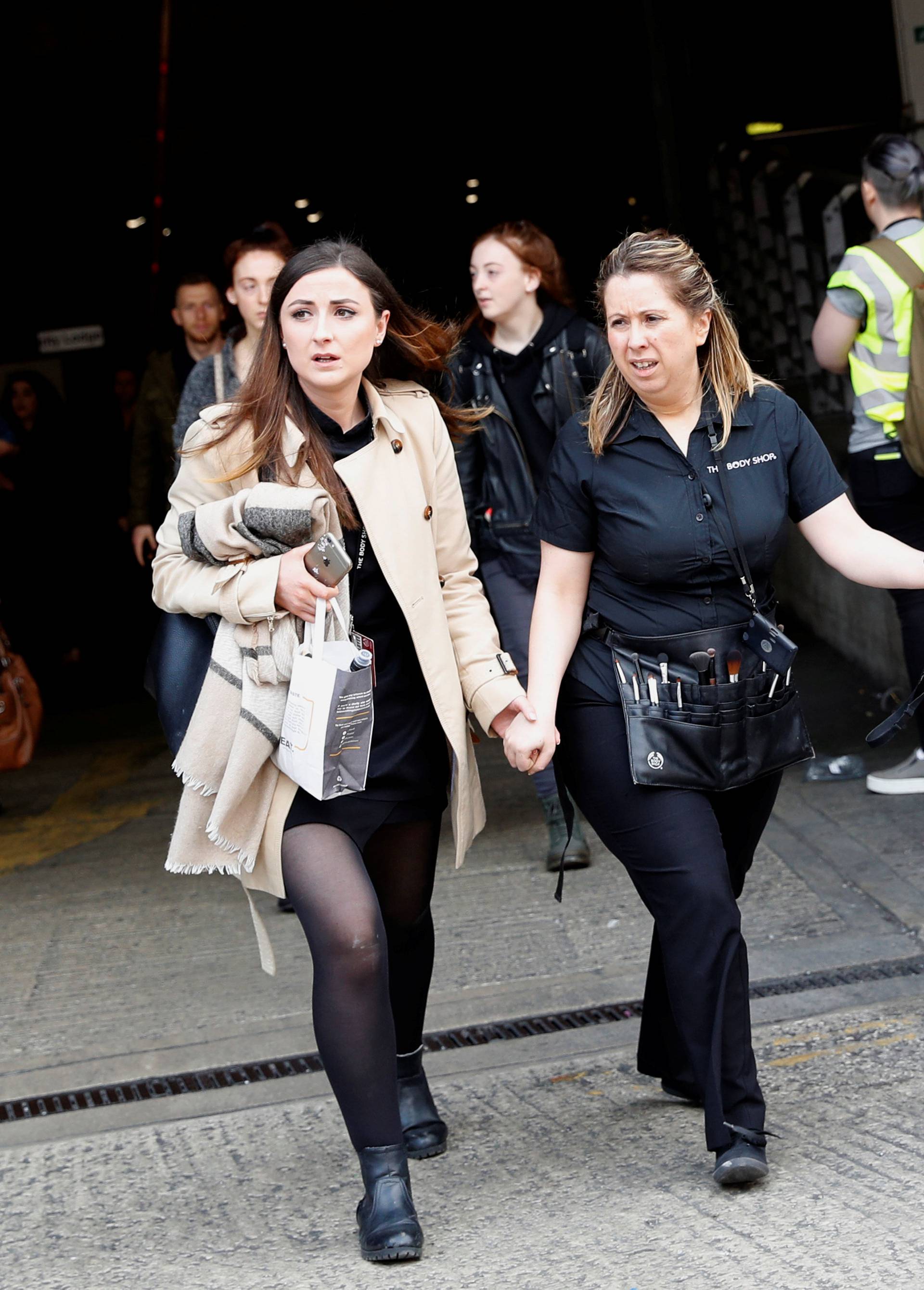 People rush out of the Arndale shopping centre as it is evacuated in Manchester