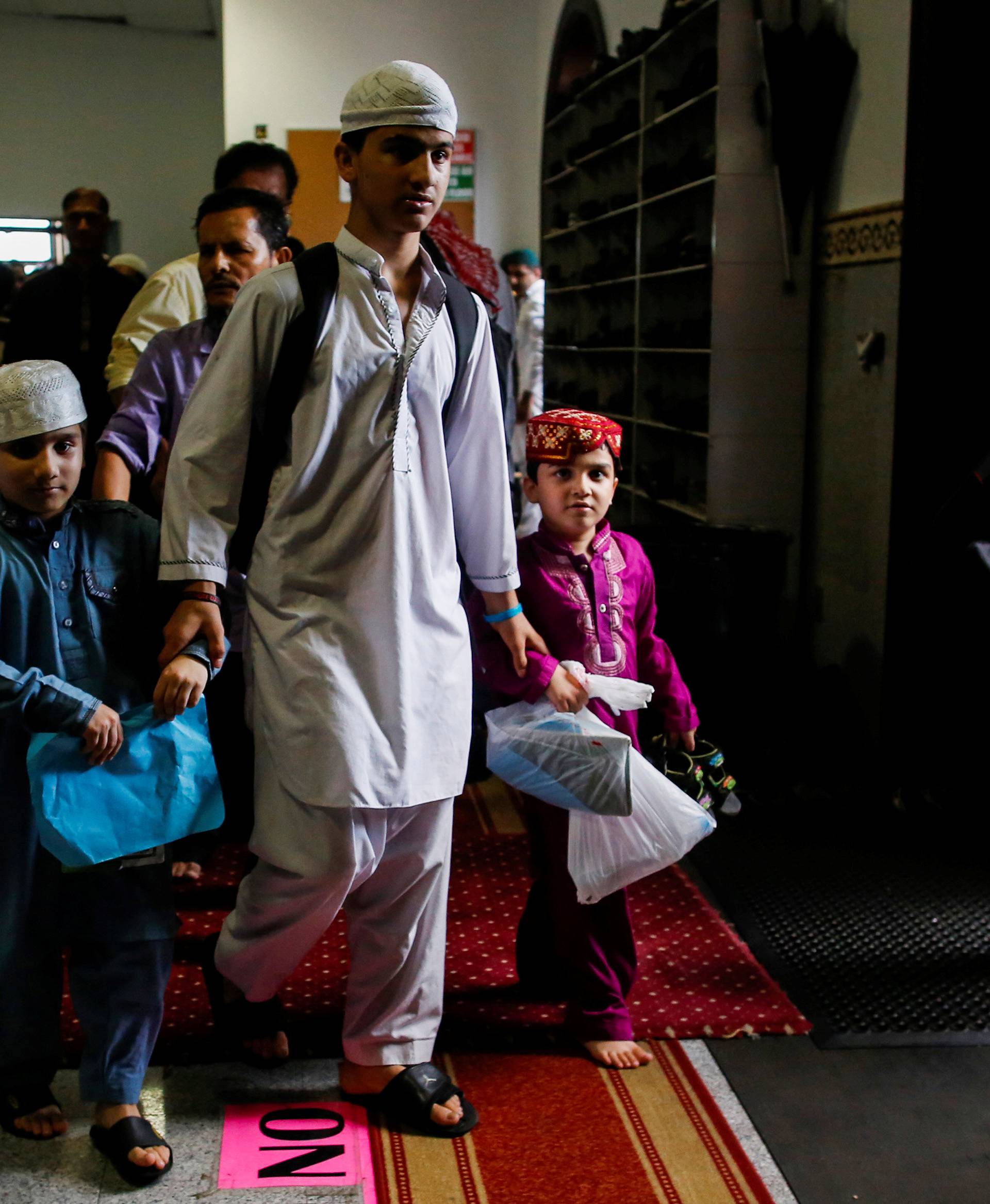 Community members attend prayers inside of a mosque before the funeral service of Imam Maulama Akonjee, and Thara Uddin in the Queens borough of New York City