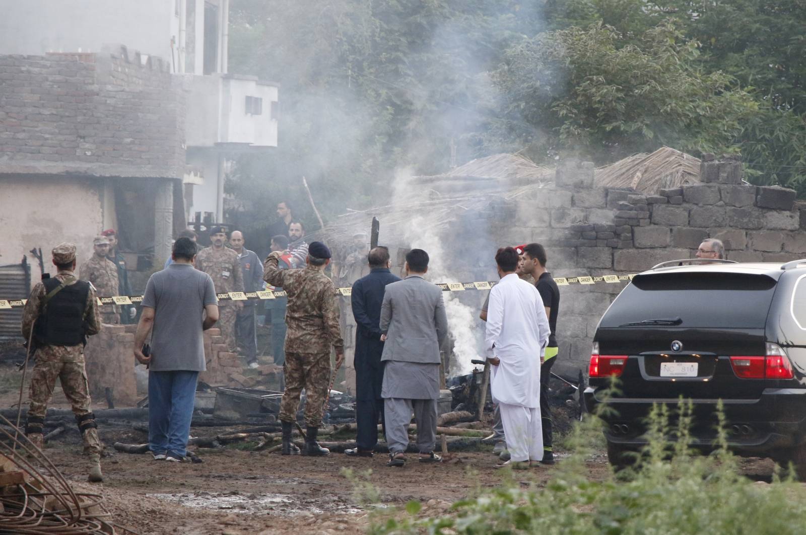 Pakistan soldiers and officers survey the site after a military aircraft on a training flight crashed in a built-up area in the garrison city of Rawalpindi,