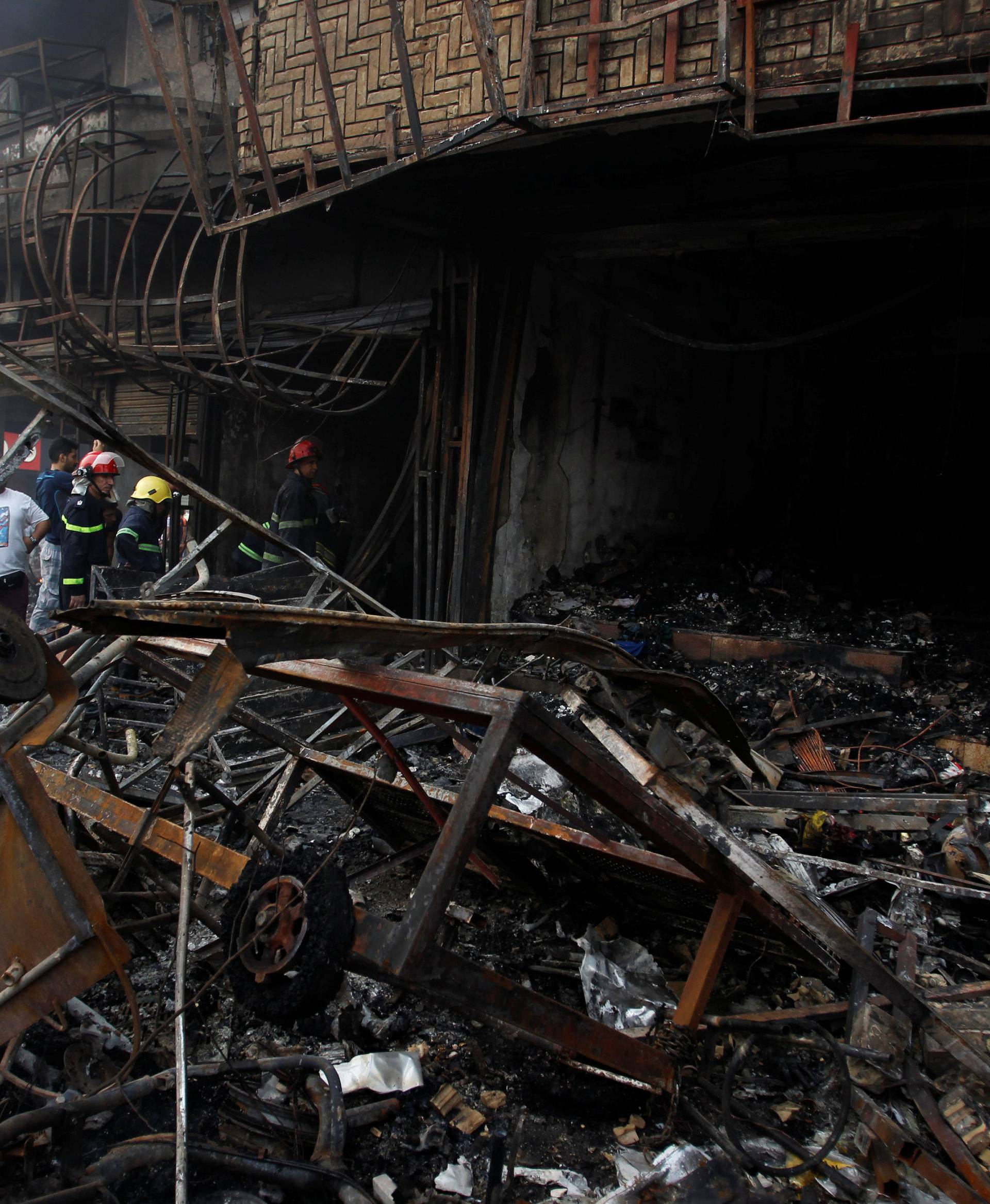 People gather at the site of a suicide car bomb in the Karrada shopping area, in Baghdad, Iraq 