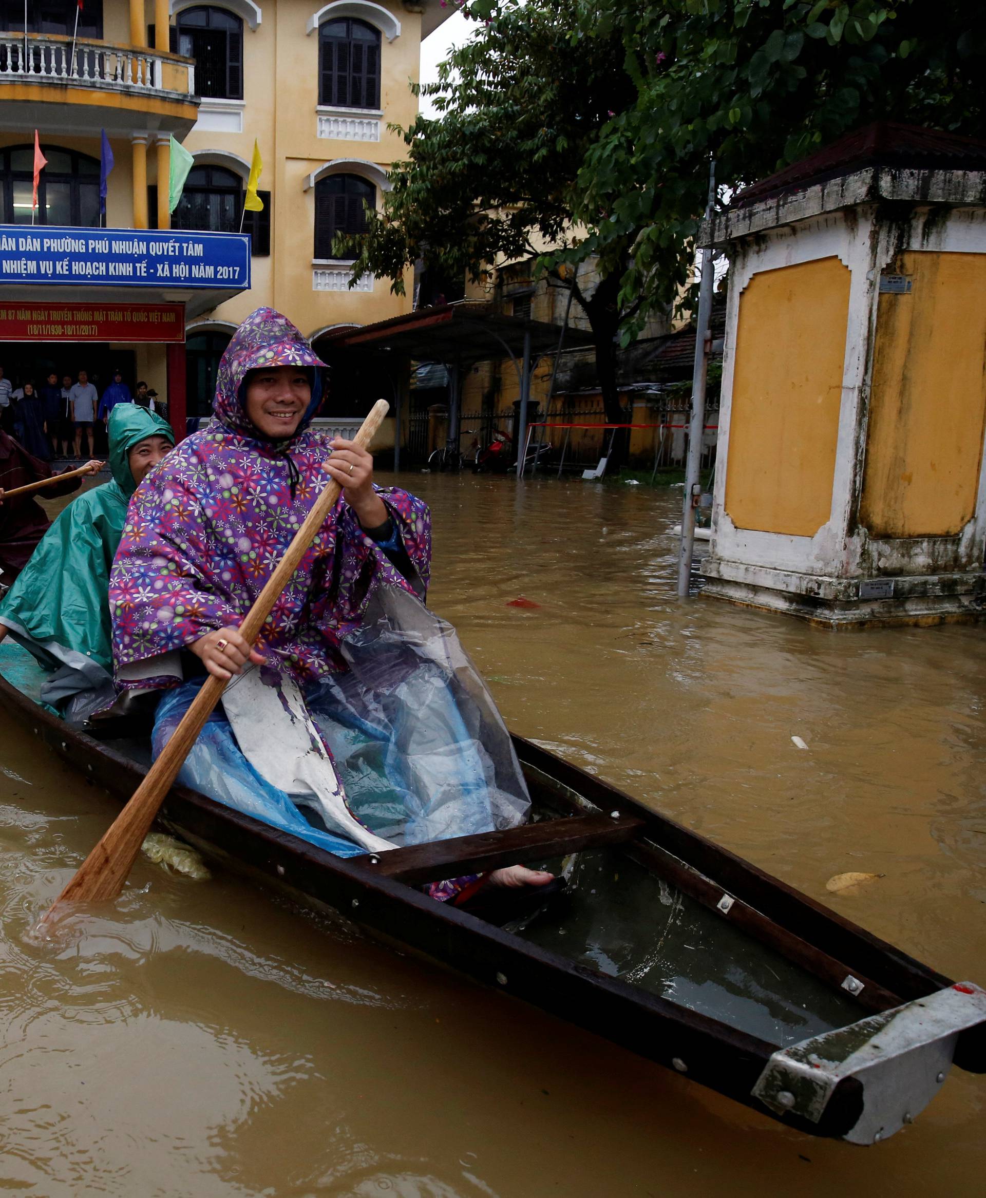 Officials sail a boat out of a submerged local government building after typhoon Damrey hits Vietnam in Hue city