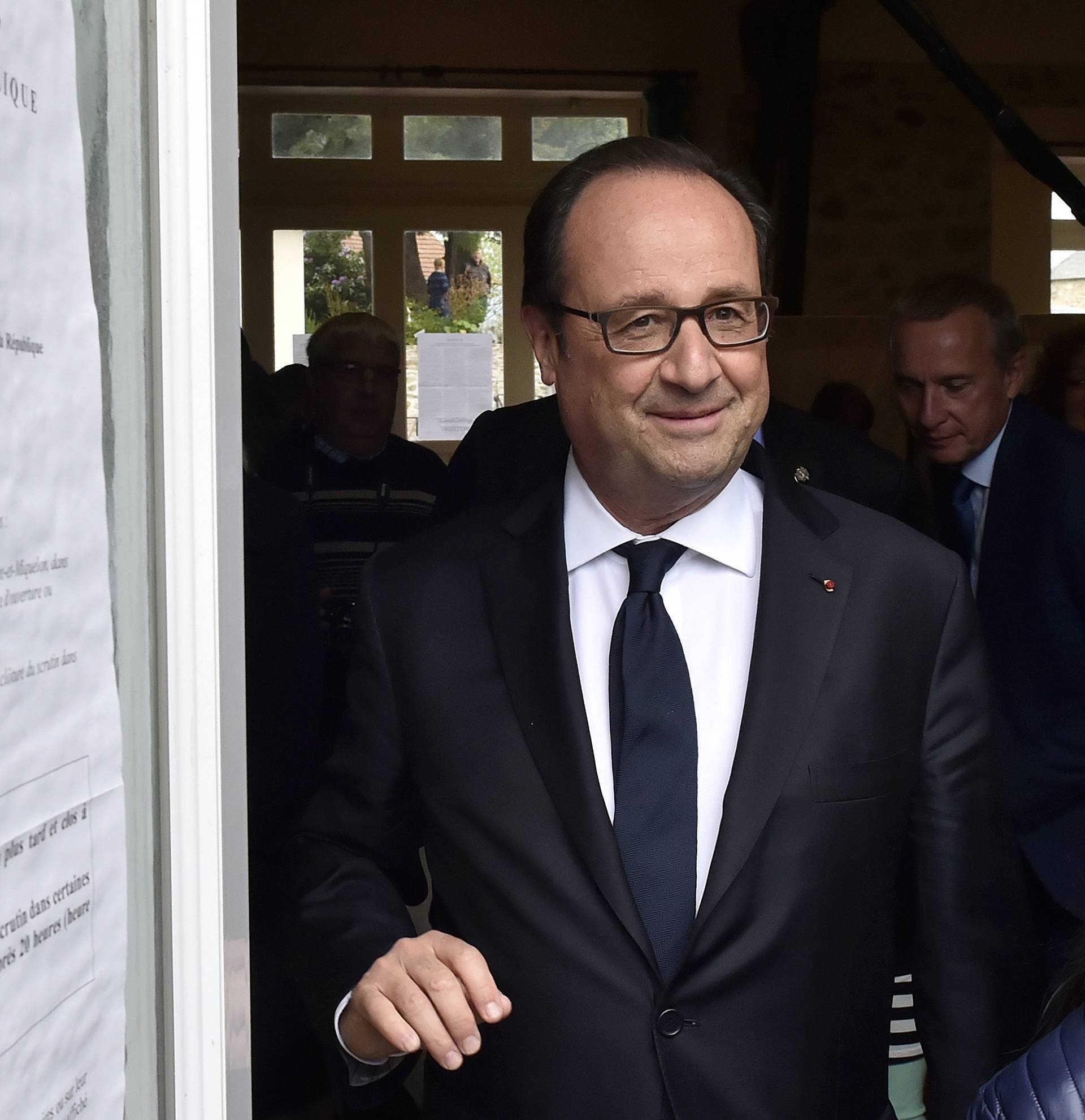 French President Francois Hollande leaves after visiting a polling station in the second round of the 2017 French presidential election, in the village of Saint Mexant
