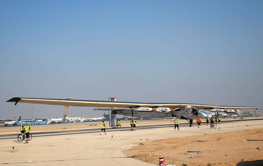 The ground crew of Solar Impulse 2, a solar powered plane, surround the aircraft after it landed at Cairo Airport