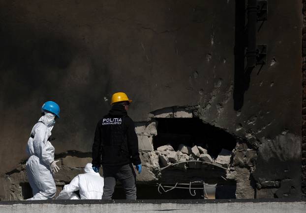 Law enforcement work on the site of an explosion at a residential block of flats following a drone hit in Galati