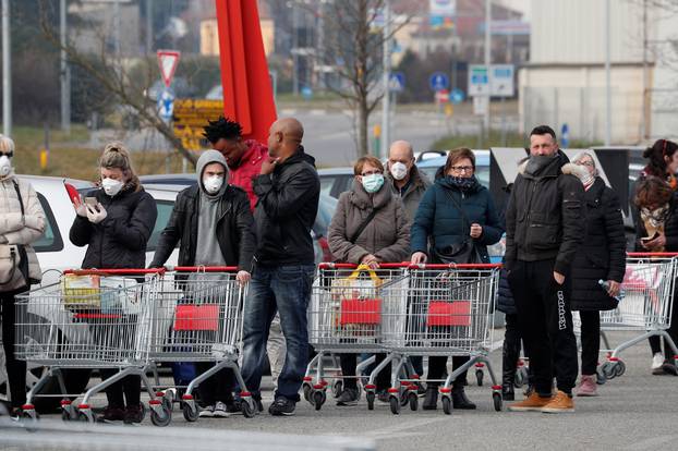 People queue at a supermarket outside the town of Casalpusterlengo