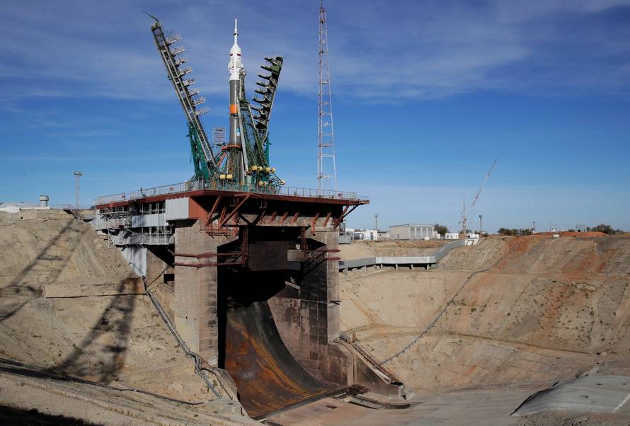 Service towers move towards Russia's Soyuz-FG booster rocket with the Soyuz MS-10 spacecraft at the launch pad at Baikonur Cosmodrome