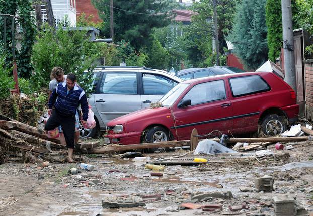 People walk on the street after heavy floods in Cento near Skopje