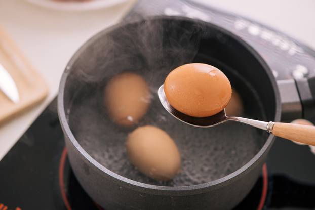 Chef putting boiled eggs in cup / Cooking sweet brown Stewed pork gravy (Moo Pa-lo) concept
