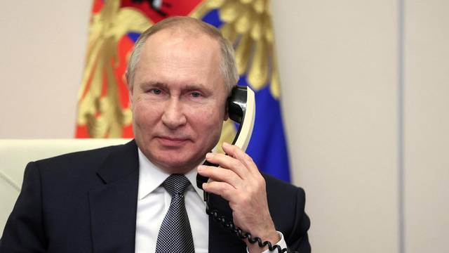Russian President Vladimir Putin speaks on the phone at his residence outside Moscow